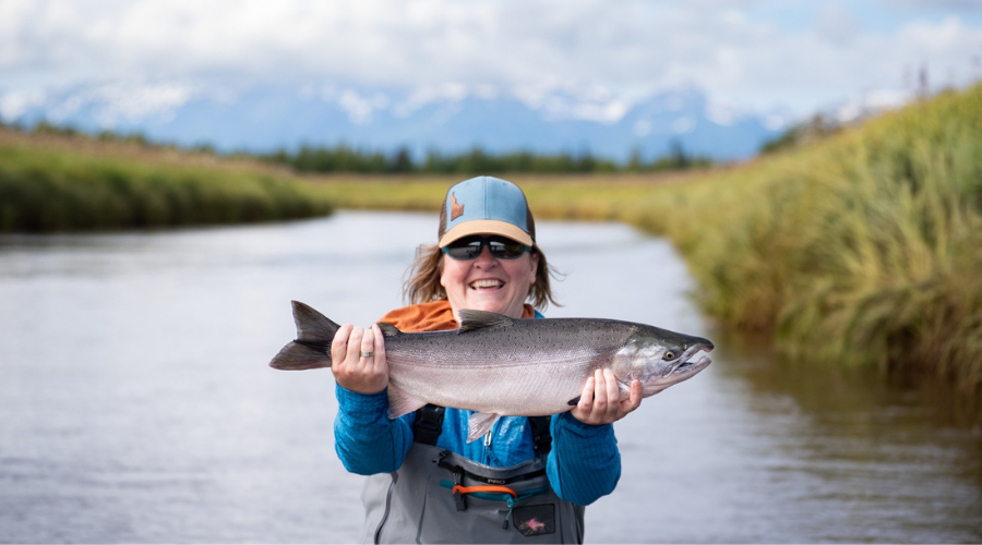 Rachel Dykstra holding a large salmon on the Kenai River in Alaska