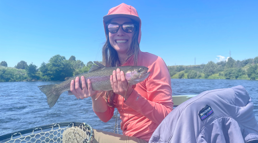 Kylie Bolland holding a rainbow trout while fly fishing